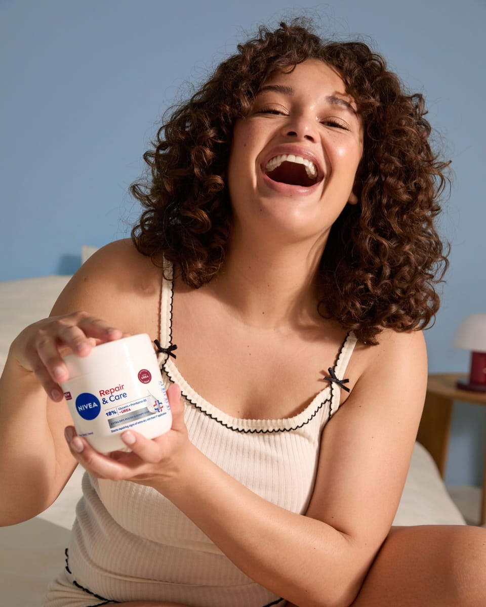 Junge Frau verwendet NIVEA Repair- und Pflegecreme