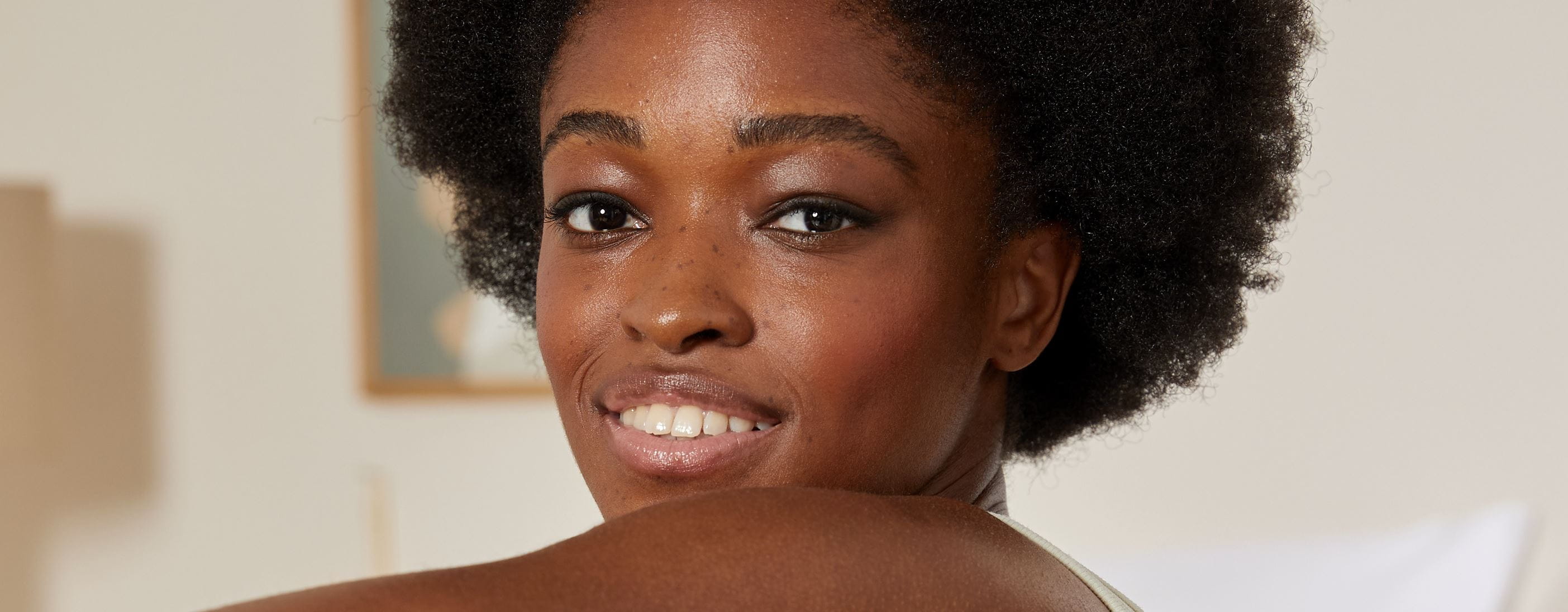 Frau mit afrostrukturiertem Haar, lächelnd
